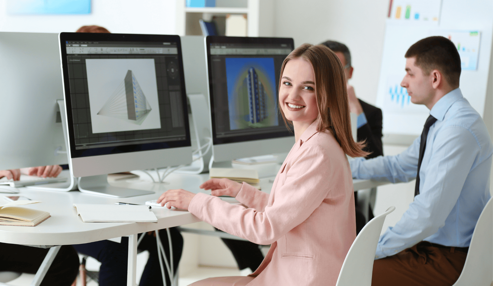 En kvinna sitter vid en dator i ett kontorslandskap och arbetar