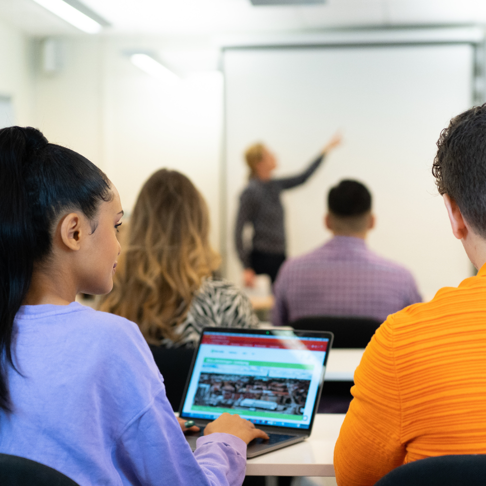 Foto av deltagare som sitter och lyssnar på föreläsning.